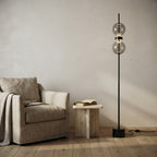Lampadaire fin en métal noir à deux globes Lorgnette – mise en situation (visuel d’ambiance)