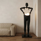 Lampadaire sculpture en résine silhouette humaine globe en main Foyer – mise en situation (visuel d’ambiance)