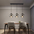 Suspension en verre trois globes fumés sur rampe Fumerolle