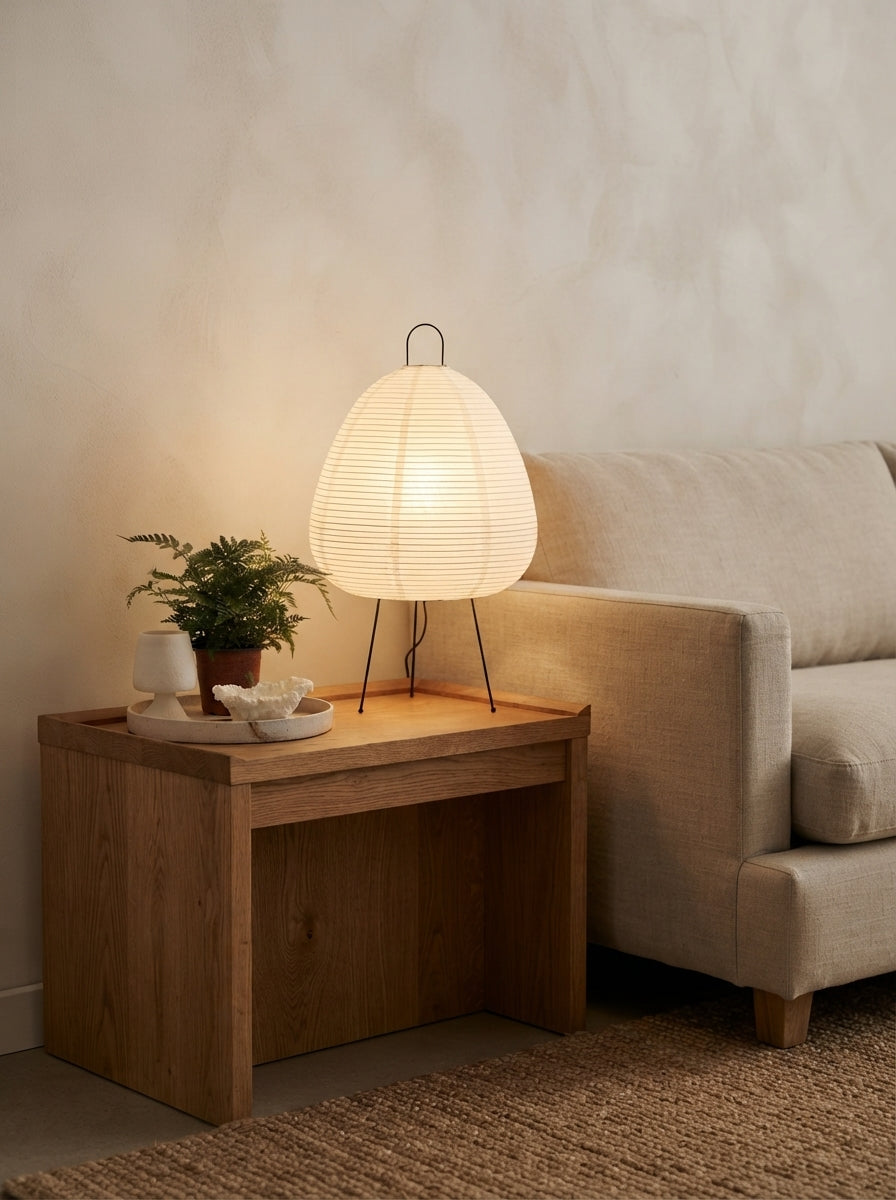 Lampe à poser en papier plissé sur une table d'appoint en chêne